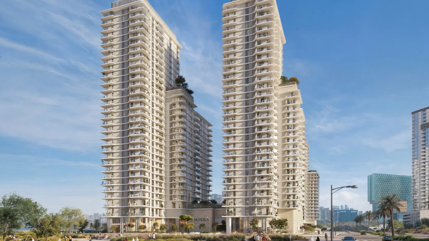 Two tall cream towers with curved balconies above a landscaped street corner