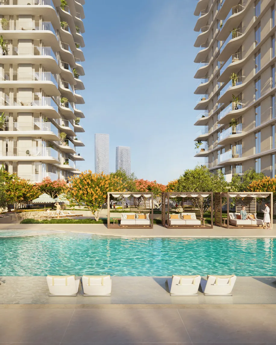Pool with cabanas and flowering trees between the two towers